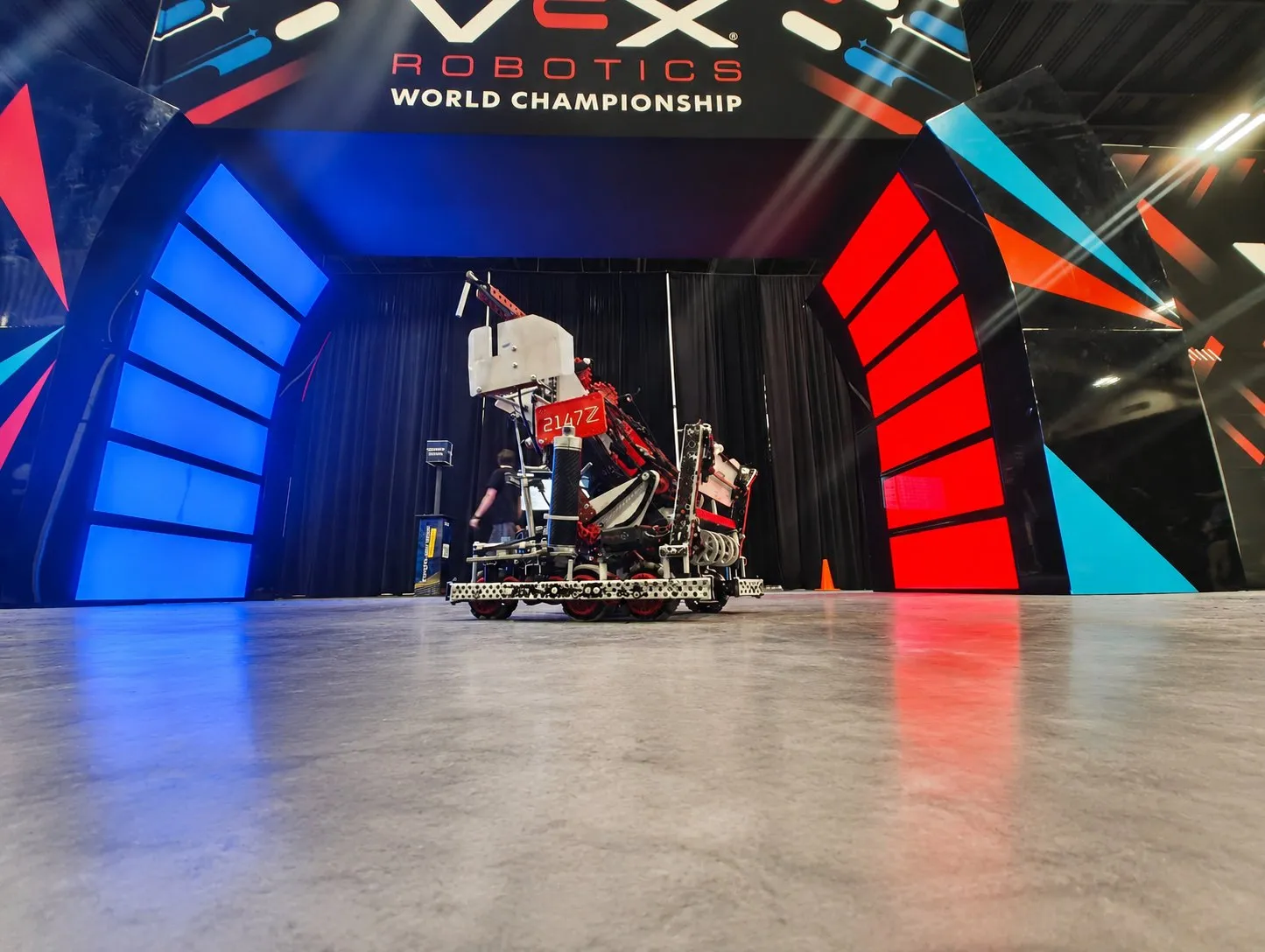 The Push Back robot, number 2147Z, on the VEX World Championship stage between blue and red lit arches.